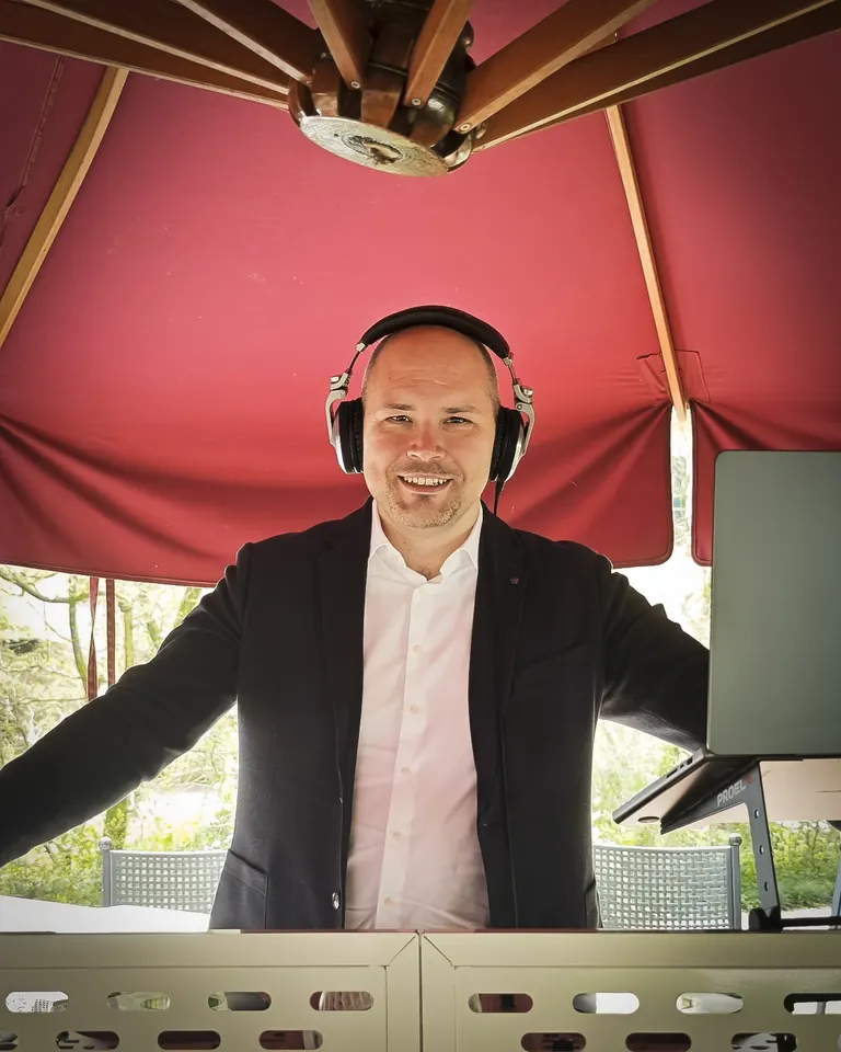 DJ con cuffie alla console durante un evento all'aperto